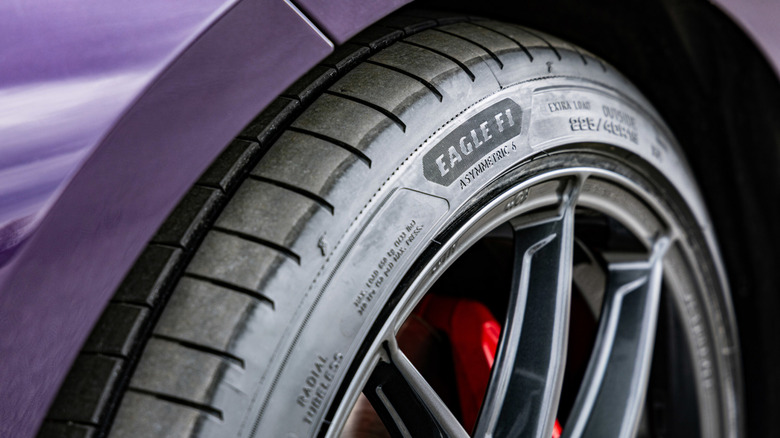 Close shot of sidewall of Goodyear Eagle F1 Asymmetric 6 tire, mounted on wheel on purple car