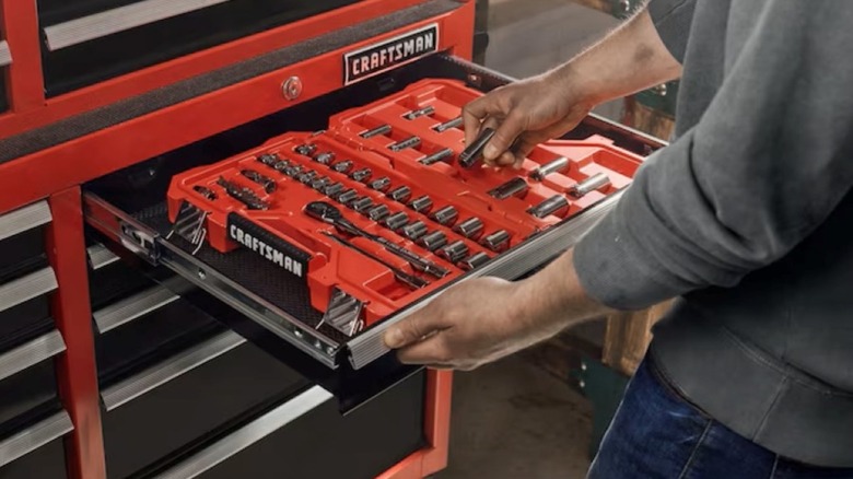 A person is selecting a tool from a Craftsman tool chest.