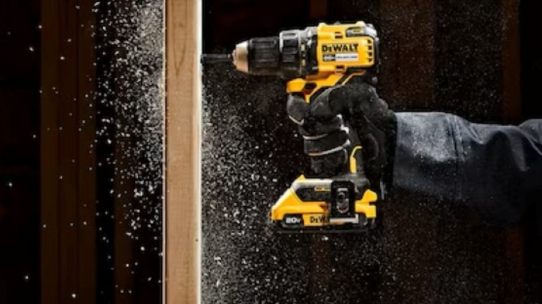 Drilling a hole through a wooden stud with a DeWalt drill.