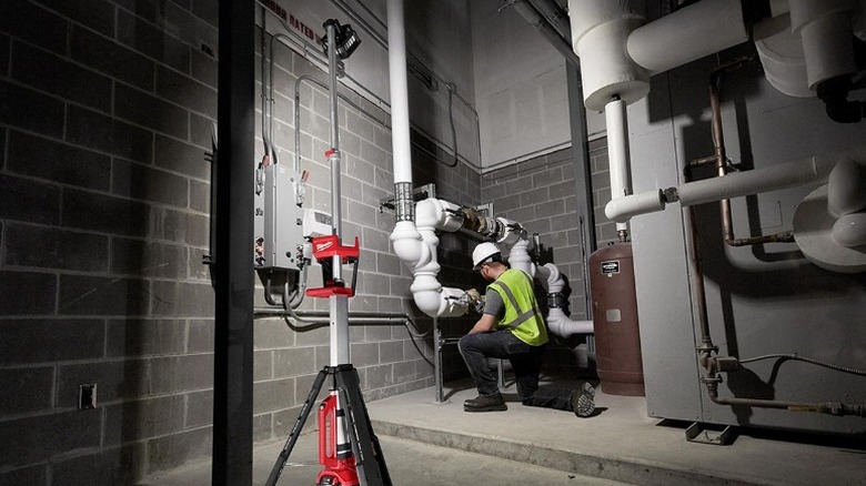 Person working under Milwaukee M18 Cordless Rocket Dual Power Light
