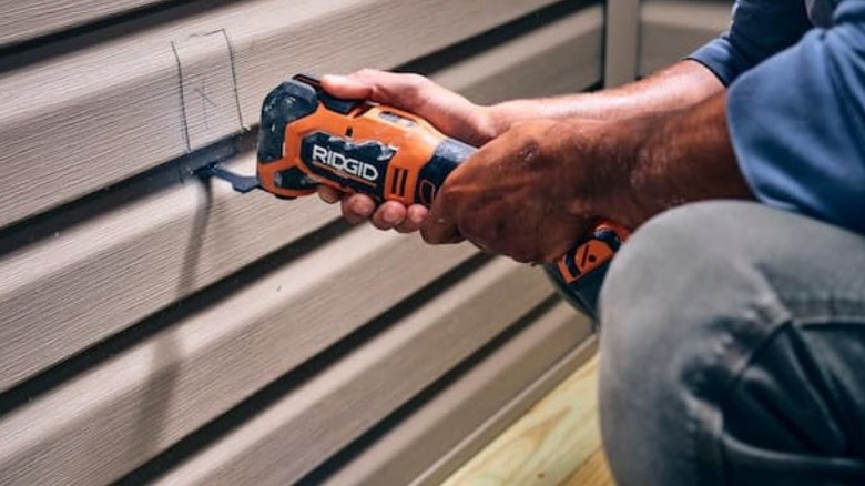 Person using Ridgid 18V Nuke SubCompact Brushless Cordless Multi-Tool on wall