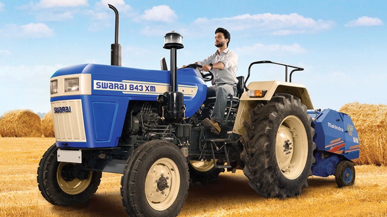 A person riding a Swaraj tractor.