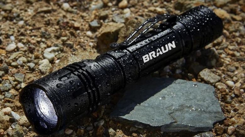 A Harbor Freight Braun 1800 lumen flashlight sitting on the ground