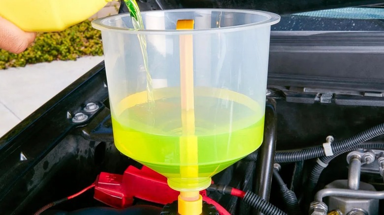 A person using the Pittsburgh no fill funnel to add coolant to their car