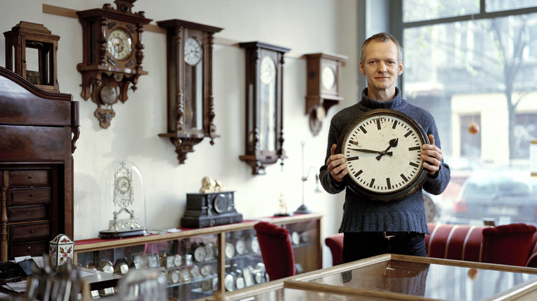 A man with a collection of old clocks.