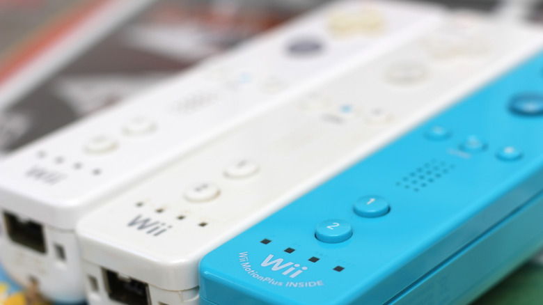Three Wii Remotes, two white and one blue.
