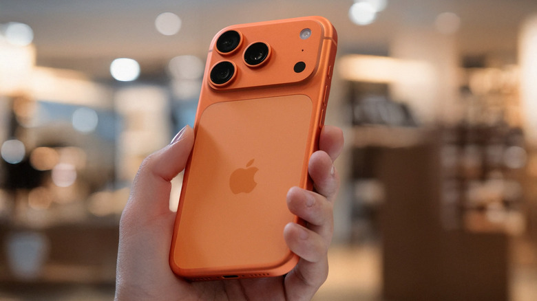 Person holding an orange iPhone 17 Pro