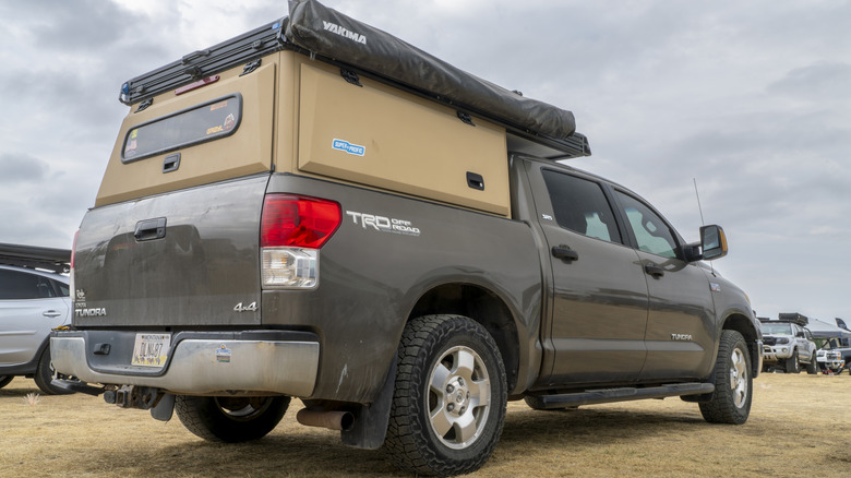 Rear 3/4 view of Toyota Tundra with camper shell and tent