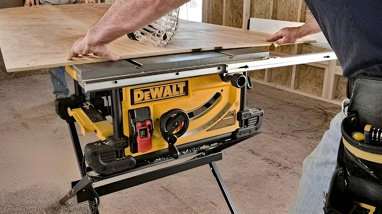 Man lining up wood board on DeWalt table saw