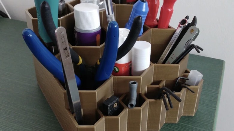3D printed tool organizer filled with hand tools and crafting supplies.
