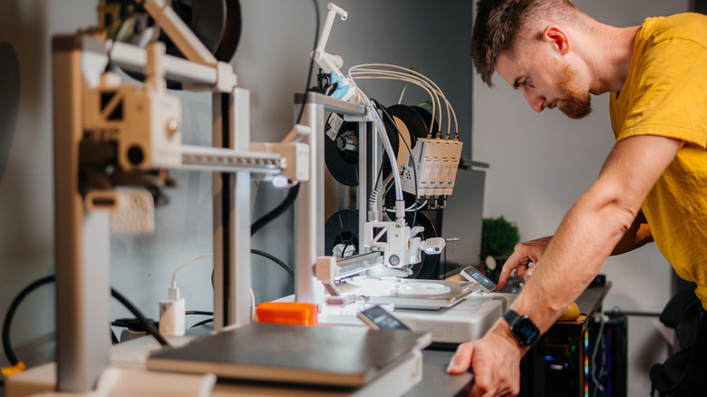 Man programming 3D printer