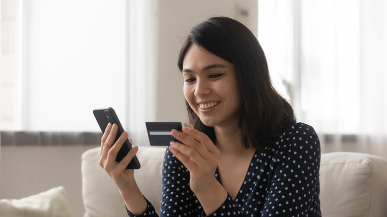 Woman holding card and smartphone