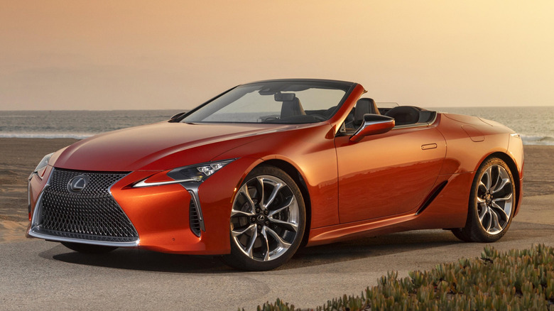 Front 3/4 view of Lexus LC 500 Convertible in beach setting by the sea