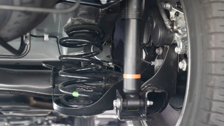 Close shot of rear suspension on car showing spring and shock absorber