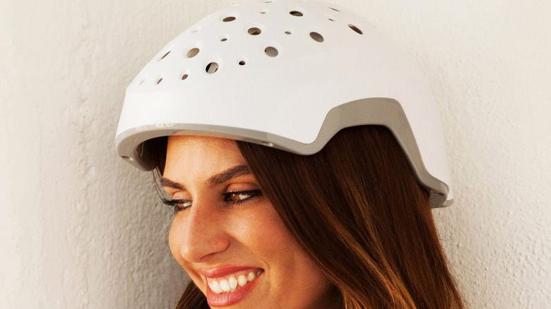 A woman wearing the Theradome EVO device on her head.