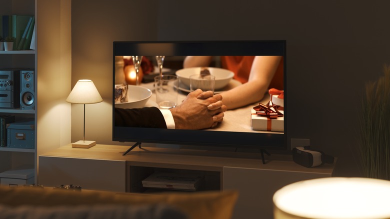 A TV playing a movie in a low-lit room