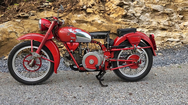 A red Moto Guzzi 500 cc bike, finished in the Falcone body style, with the paint chipping off the tank.