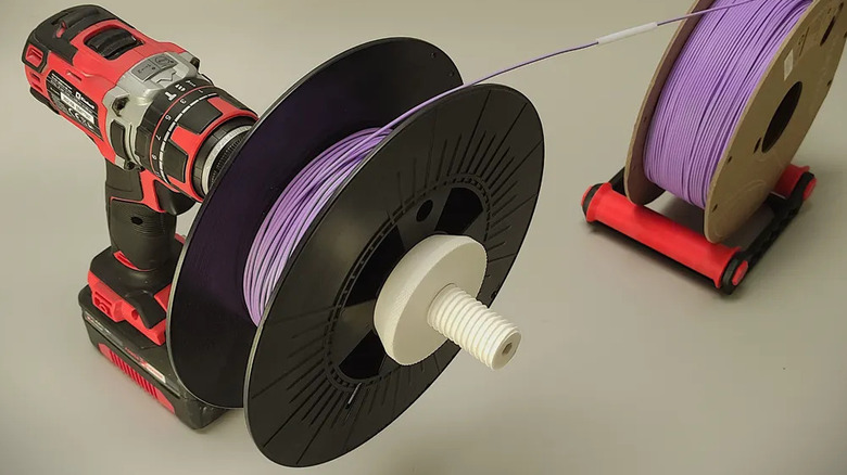 Filament respooler tool with a power drill unwinding a refill spool