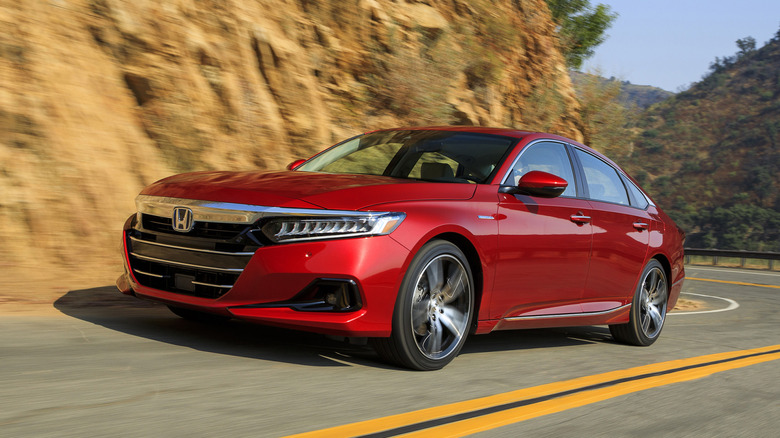 Front view of red Honda Accord Hybrid driving on mountain road.