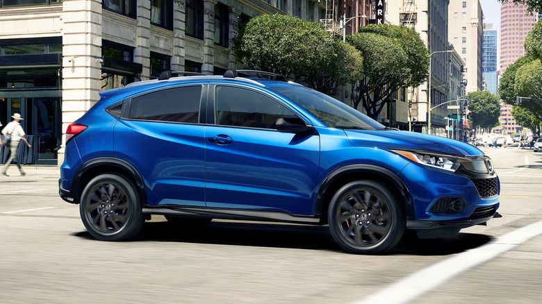 Side view of blue Honda HR-V driving on urban street.