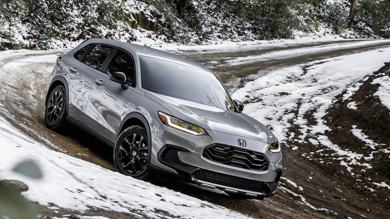 Front 3/4 view of gray Honda HR-V on snowy mountain trail.