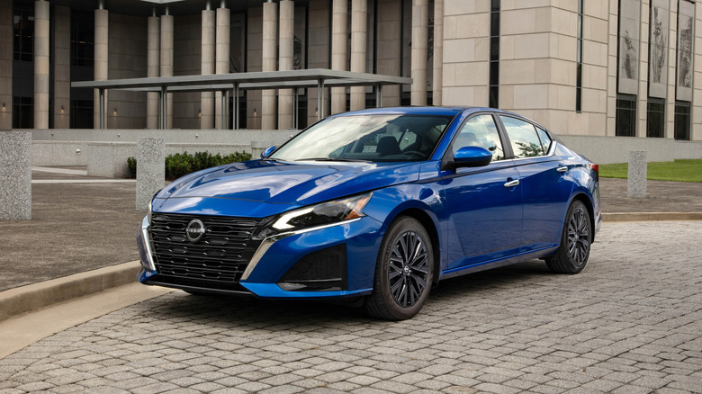 2025 Nissan Altima SV in blue outside a large building, front 3/4 view