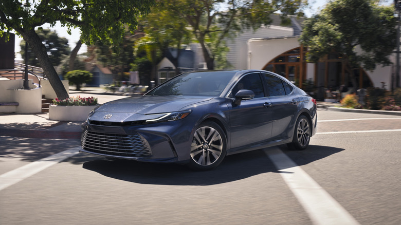2026 Toyota Camry in blue, front 3/4 view, urban background