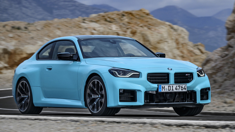 Front 3/4 view of BMW M2 on winding road in mountainous setting