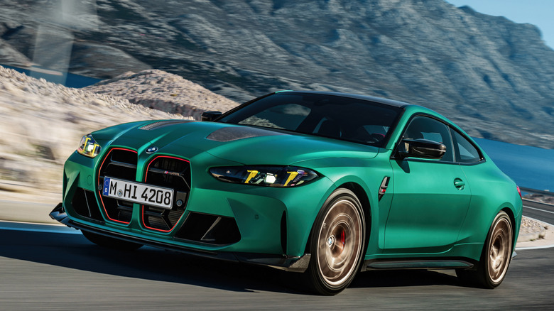 Front 3/4 view of BMW M4 CS on winding lakeside mountain road