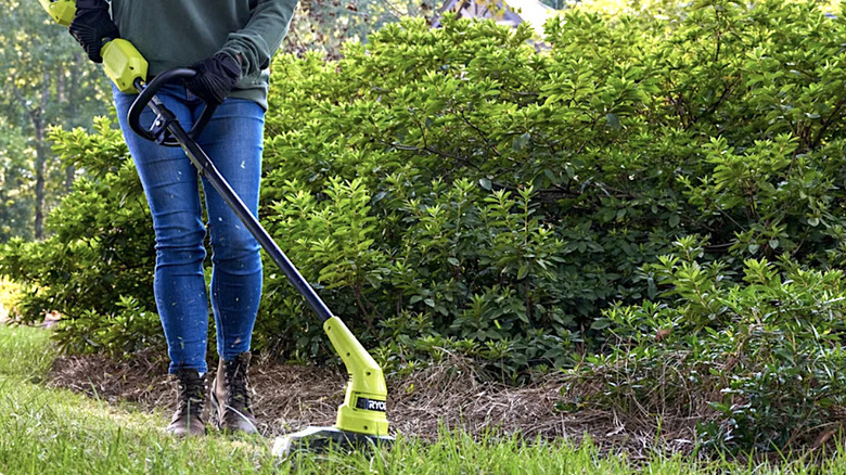 Person using Ryobi 40V string trimmer