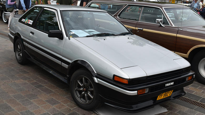 Front 3/4 view of silver Toyota AE86 Trueno parked at car show.