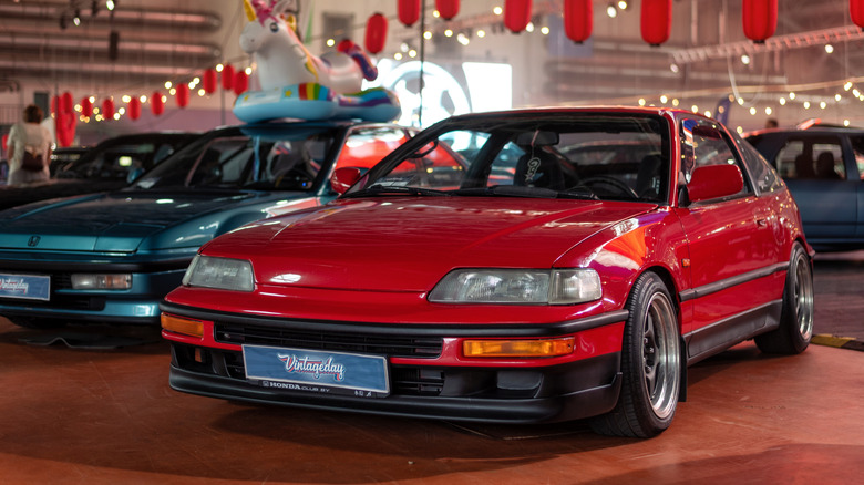 Front 3/4 view of red Honda CRX parked at indoor car show.