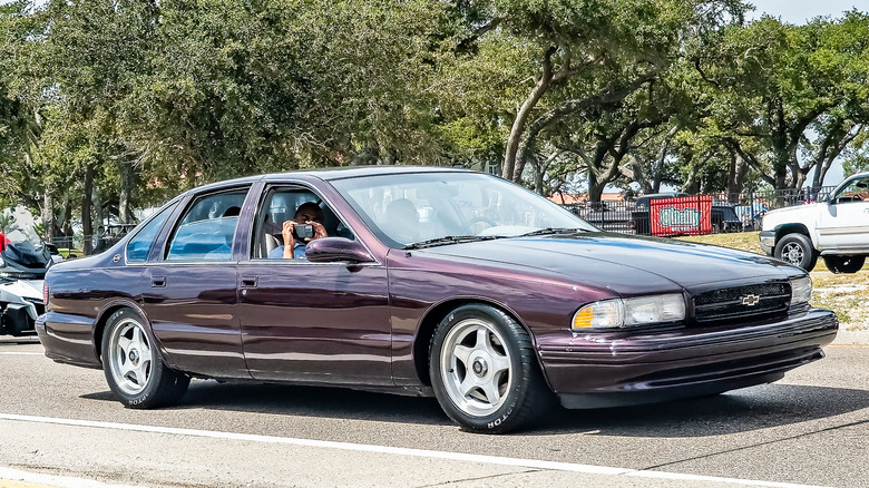 Front 3/4 view of purple 1996 Chevy Impala at car show.