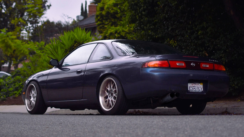 Rear 3/4 view of S14 Nissan 240SX parked on street.