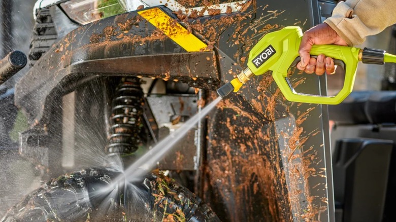 A person pressure-washing a vehicle with the Ryobi Automotive Pressure Washer Accessory Kit.