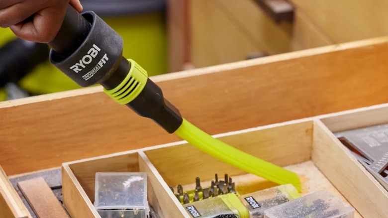A person cleaning a drawer with the Ryobi UniversalFit Wet/Dry Vacuum Micro-Crevice Tool.