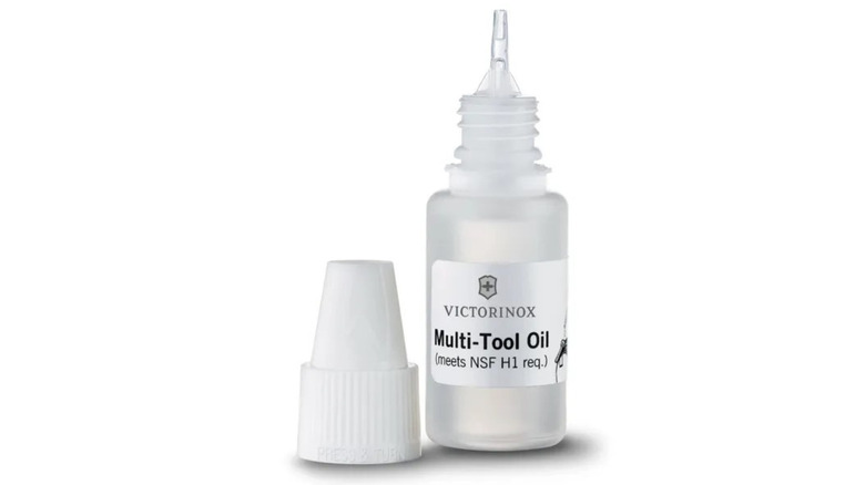 A bottle of Victorinox Multi Tool Oil with its cap off and a white background