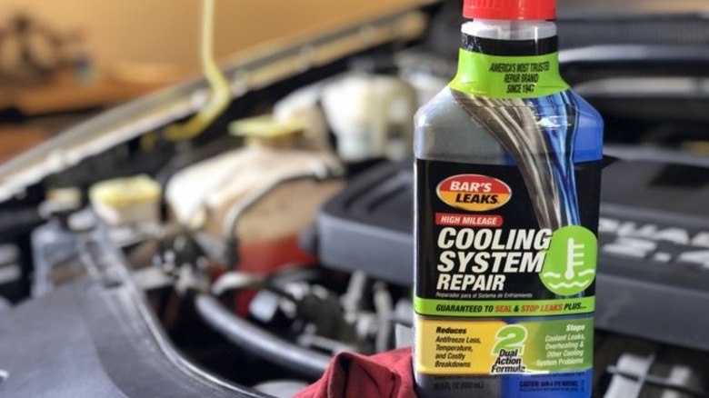 A jar of Cooling System Repair resting on an engine