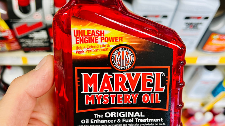 A hand holding up a bottle of Marvel Mystery Oil