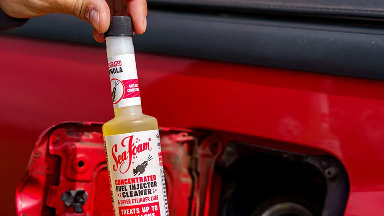 A person opening a bottle of Sea Foam