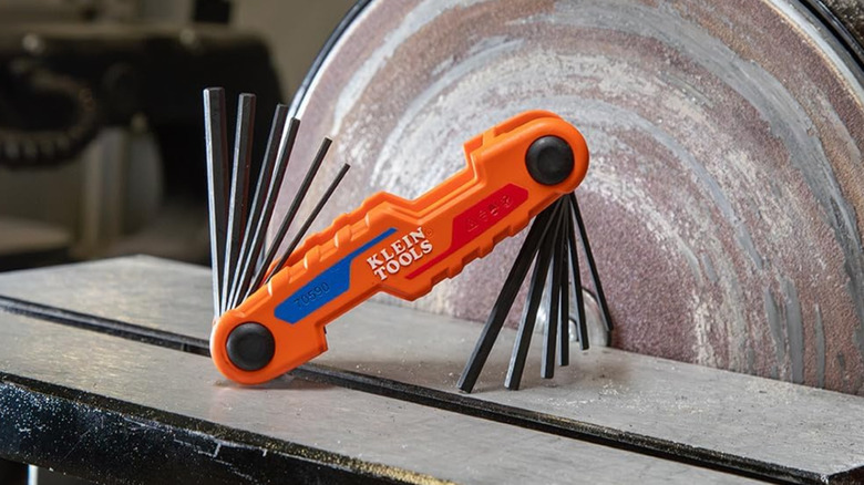 A Klein Tools Compact Folding Hex Key, half-open on a table.