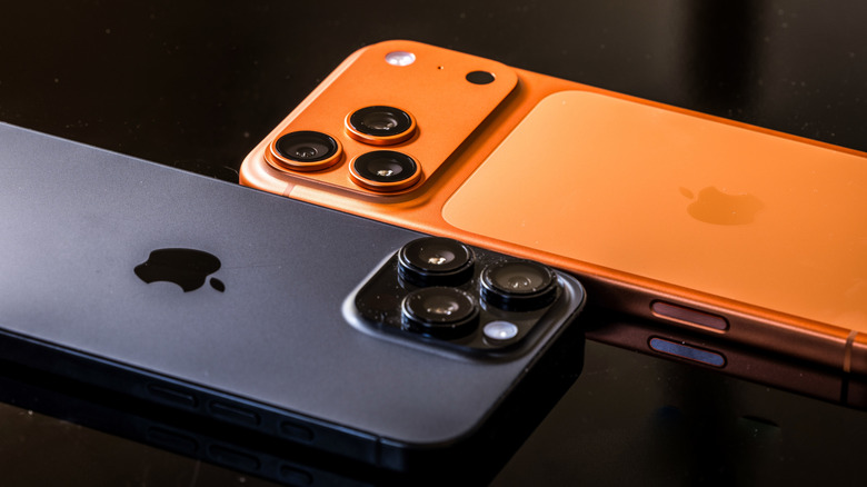 Orange iPhone 17 Pro Max and black iPhone 16 Pro Max next to each other, showing camera assemblies