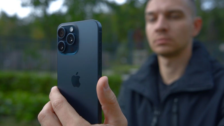 Man taking a photo with an iPhone 15