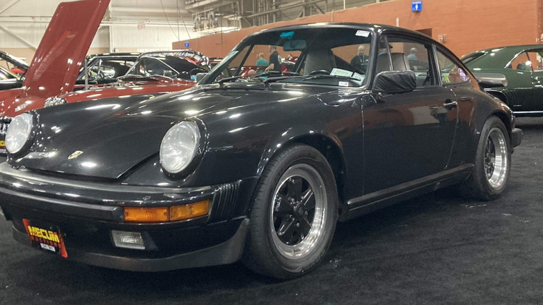 1989 Porsche 930 Turbo parked indoors at auto show, a typical small-displacement turbo sports car, front-left 3/4 view