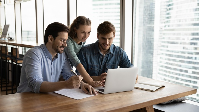 Team sharing a laptop