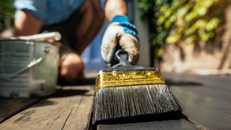 homeowner painting a deck