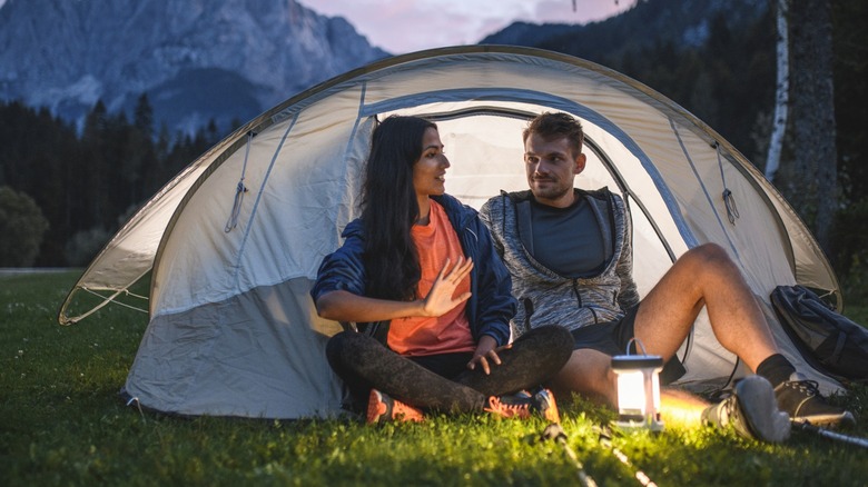 Man and woman in tent with lantern lit