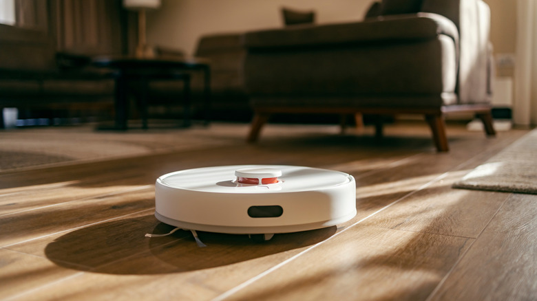 White robot vacuum on a wooden floor