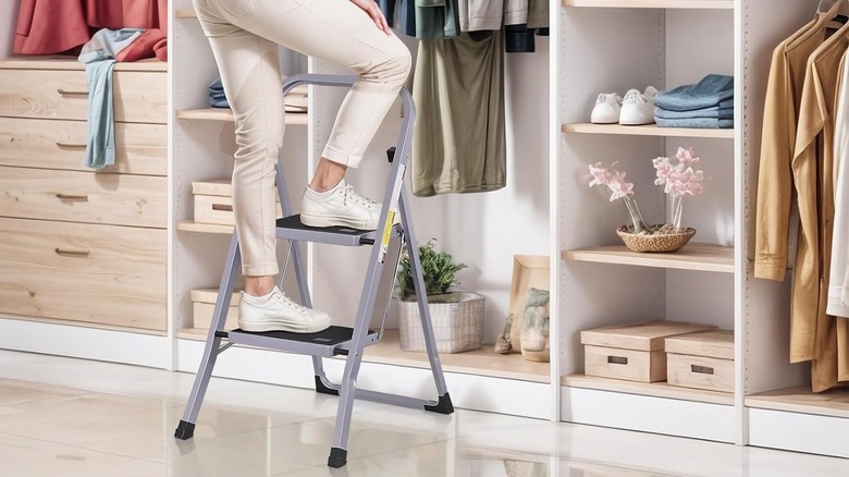woman using ladder next to closet