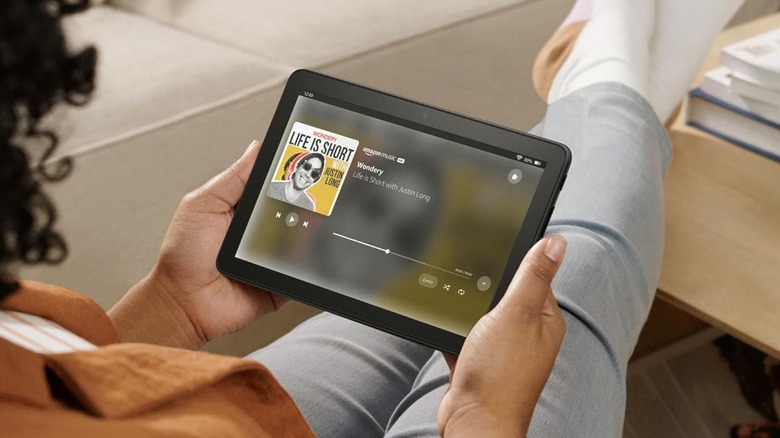 A person holding an Amazon Fire HD 8 tablet browsing Amazon Music.